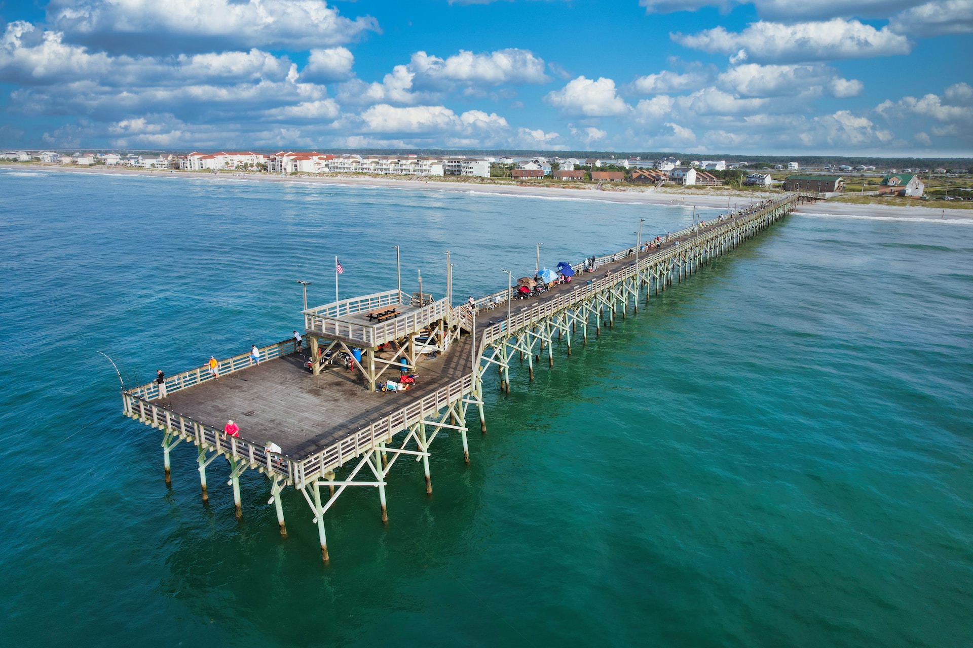 A pier with people standing on it in the ocean